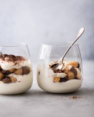 Hafif arka planda bir bardakta tiramisu tatlısı, seçici odaklanma.