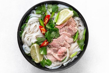 Pho Bo vietnamese soup with beef and rice noodles on a white background, top view, close-up clipart