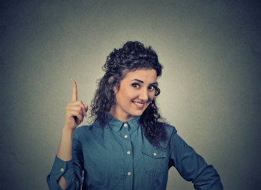 young woman has idea, pointing with finger up looking happy clipart