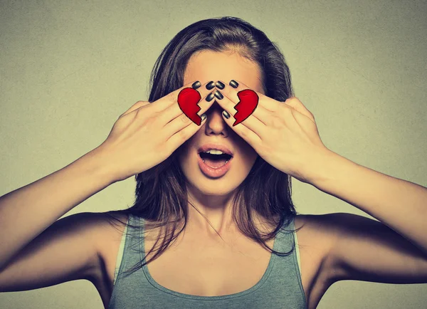 Beautiful young woman eyes covered by hands with broken heart printed on them — Stock Photo, Image