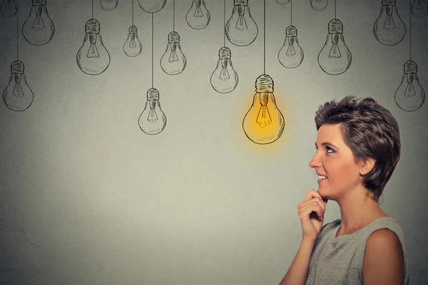 Felice donna pensante guardando con brillante lampadina idea di luce sopra la testa — Foto Stock