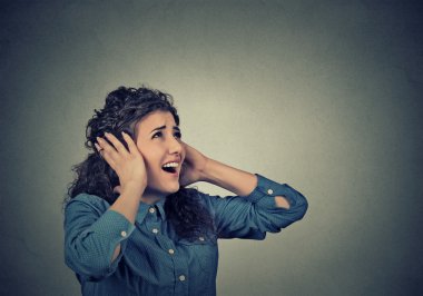 unhappy stressed woman covering her ears looking up stop making loud noise 