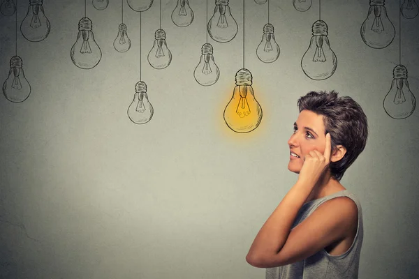 Thinking woman  looking up with light idea bulb above head — Zdjęcie stockowe