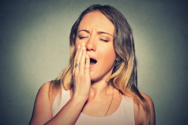sleepy young woman with wide open mouth yawning eyes closed looking bored