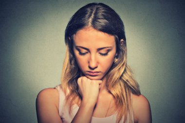 problems. Sad woman isolated on gray wall background 