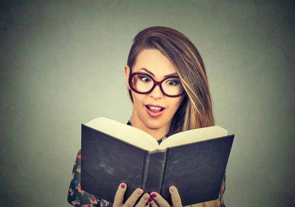 Young woman in glasses reading big book — Stok fotoğraf
