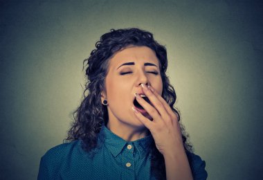 sleepy young woman with wide open mouth yawning eyes closed