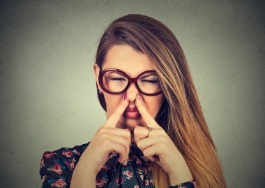 woman pinches nose with fingers looks with disgust bad smell clipart