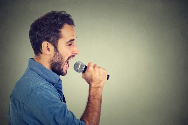 Співаюча людина ізольована на сірому фоні стіни — стокове фото