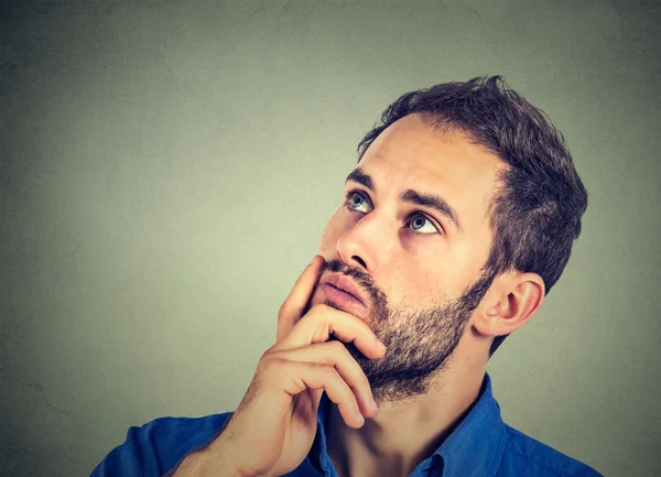 Man resting chin on hand thinking daydreaming, staring thoughtfully upwards — Stock Photo, Image