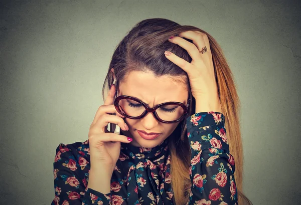 Unhappy desperate young woman talking on mobile phone looking down. — Stock Photo, Image