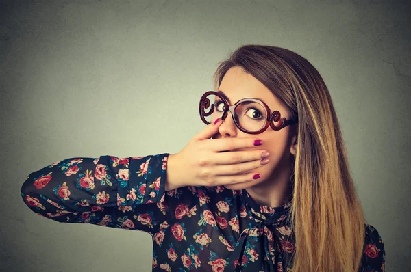 Retrato de cerca de una joven asustada en gafas cubriendo con la mano su boca — Foto de Stock