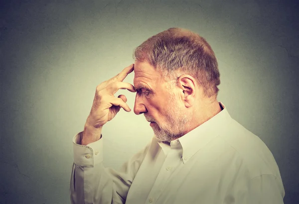 Close-up portret van een senior doordachte man geïsoleerd op grijze muur achtergrond — Stockfoto