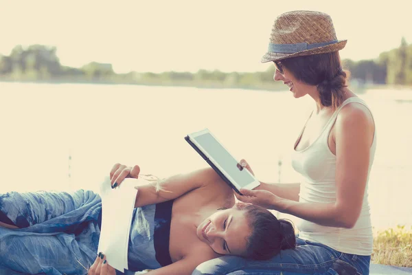 Happy women friends relaxing outdoors on green meadow on sunny spring day — Stock Photo, Image