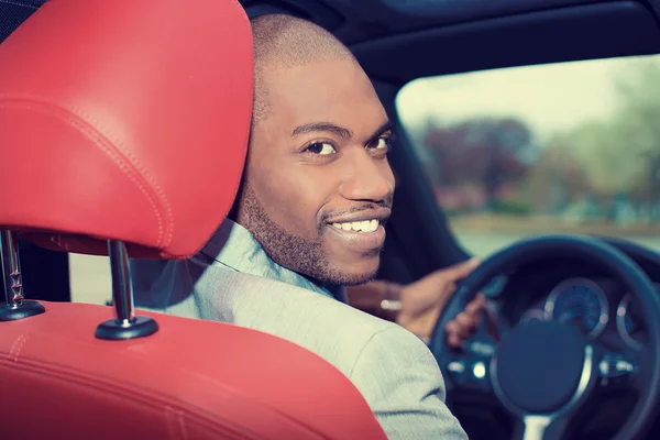 Knappe jonge man in nieuwe auto rijden — Stockfoto