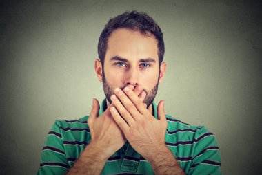 man with hands over his mouth, speechless isolated on gray wall background clipart
