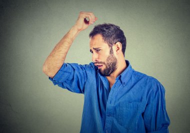 young man, smelling, sniffing his armpit, something stinks, very bad, foul odor