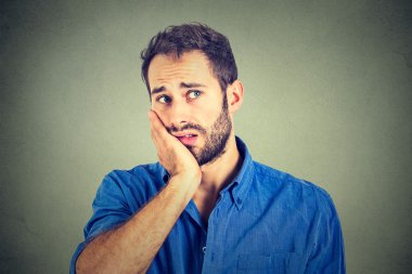 Hayatta motivasyon yok. Üzgün endişeli adam gri duvar arka plan izole 
