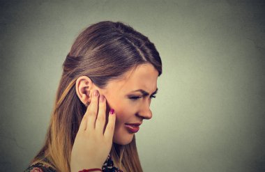 Tinnitus. Closeup side profile sick young woman having ear pain touching her painful head