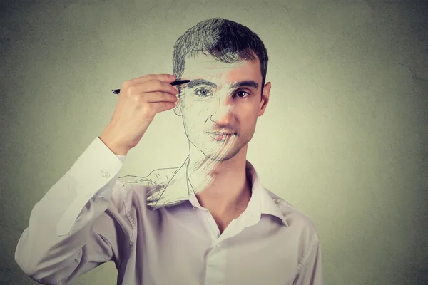 Young man drawing self portrait face, hiding true emotion. Private life, identity concept — Stockfoto