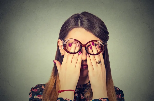 Closeup retrato jovem mulher em óculos cobrindo os olhos do rosto usando suas duas mãos — Fotografia de Stock