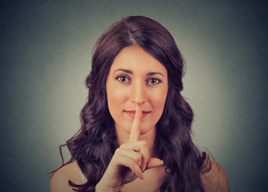 silence gesture. closeup of young woman holding placing finger on lips  clipart