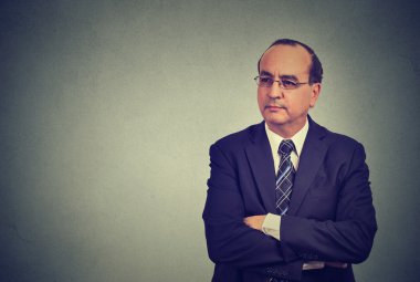 middle aged businessman in suit with crossed arms