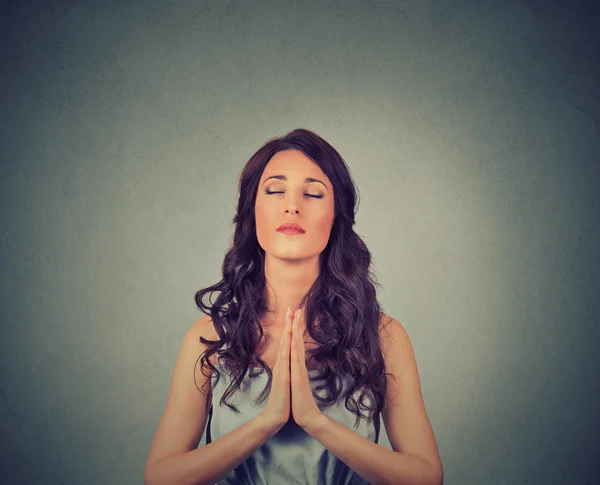 Young woman praying eyes closed isolated on gray wall background — Stock Fotó