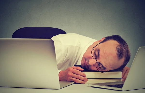 Empresário dormindo em sua mesa com laptop, cansado empregado de meia-idade — Fotografia de Stock