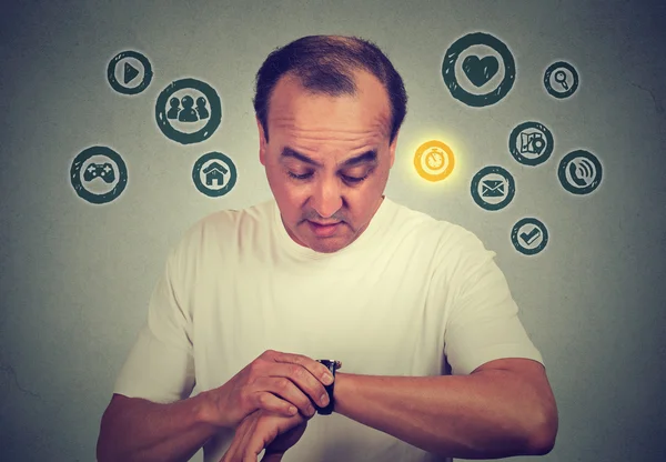 Middle age man using checking time on his smart watch with apps icons. New technology gadget concept — Stock Photo, Image