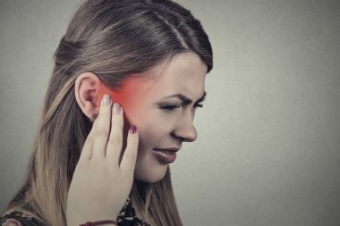 Tinnitus. Closeup yan profil hasta genç kadın kulak ağrısı olan 