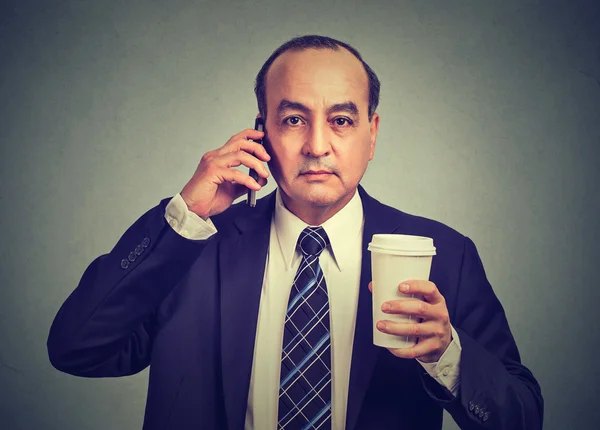 Business man talking on a cell phone holding cup of coffee — Stock Photo, Image