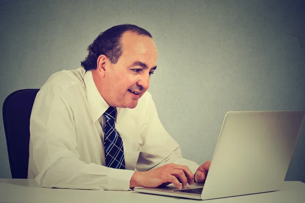 Bonito homem de negócios de meia idade feliz trabalhando com laptop no escritório — Fotografia de Stock