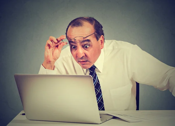 Портрет шокованого чоловіка, який читає повідомлення на комп'ютері в офісі — стокове фото