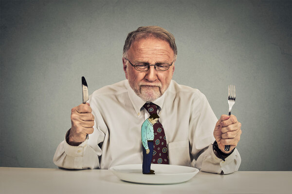 businessman with knife and fork looking at his employee on a plate