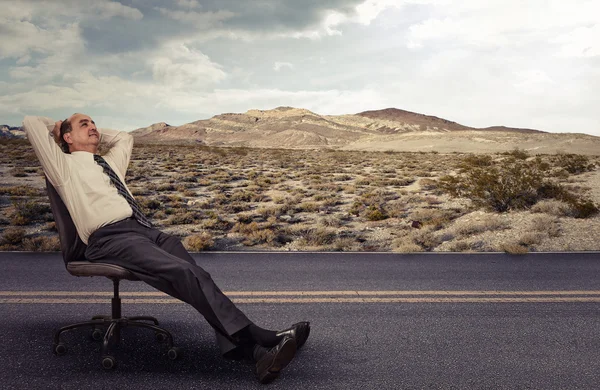 Un employé de bureau est allongé sur une chaise en plein air rêvant — Photo