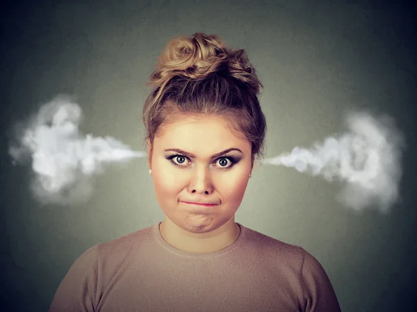 Mujer joven enojada, soplando vapor saliendo de las orejas —  Fotos de Stock