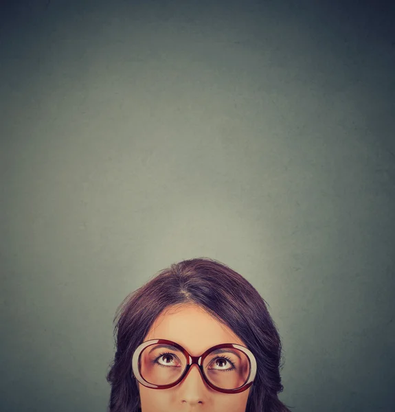 Närbild ung kvinna i glasögon tittar upp — Stockfoto