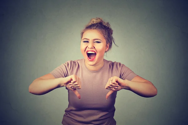 Lachende jonge vrouw toont duim omlaag gebaar — Stockfoto