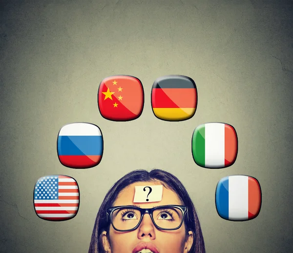 Woman with question mark icons of international flags above head — Stockfoto