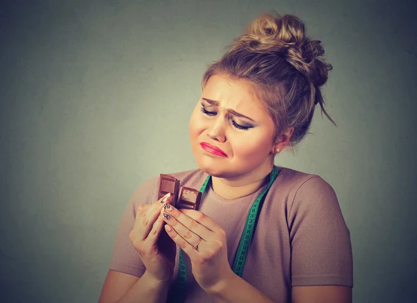Femme avec ruban à mesurer fatigué des restrictions alimentaires envie de bonbons chocolat — Photo