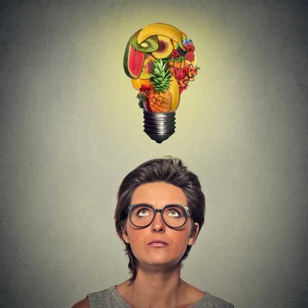 Étkezés az egészséges ötlet és diéta tippek koncepció. nő felnézett villanykörte, gyümölcsből a feje fölött — Stock Fotó