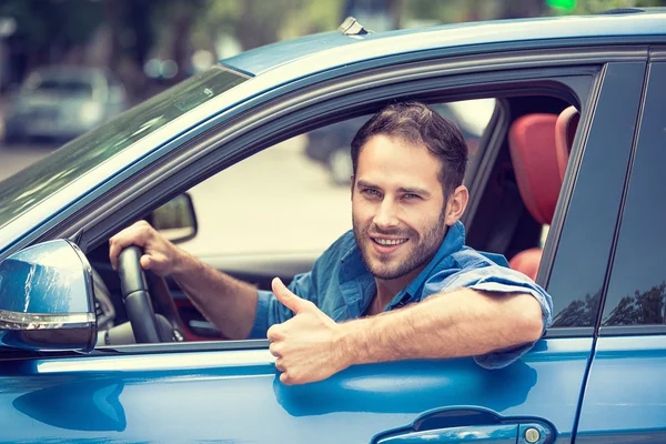 Man stuurprogramma gelukkig lachend weergegeven: duimschroef opwaarts drijvende sport blauwe auto Rechtenvrije Stockafbeeldingen