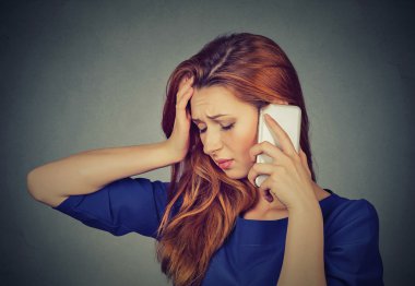 Portre mutsuz genç kadın cep telefonu aşağı bakarak konuşurken