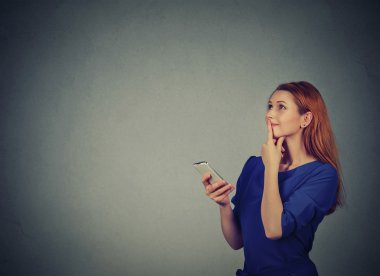 Woman texting on her mobile phone looking up planning