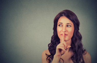 Dudaklarında parmak ile çekici genç kız portresi, öğrenci kavramını göstermek sessizlik, sessizlik, gizli jest, genç güzel esmer kadın