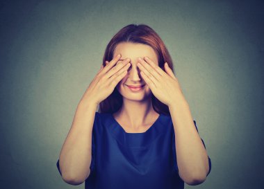 Saklanıyor. Gülümseyen gözleri kapsayan utangaç kadın