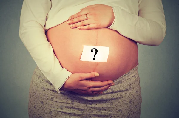 Mladá těhotná žena břicho s otazníkem — Stock fotografie