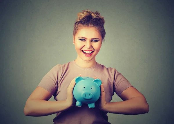 Uma mulher feliz e sorridente a segurar o mealheiro. Poupança financeira, conceito bancário . — Fotografia de Stock