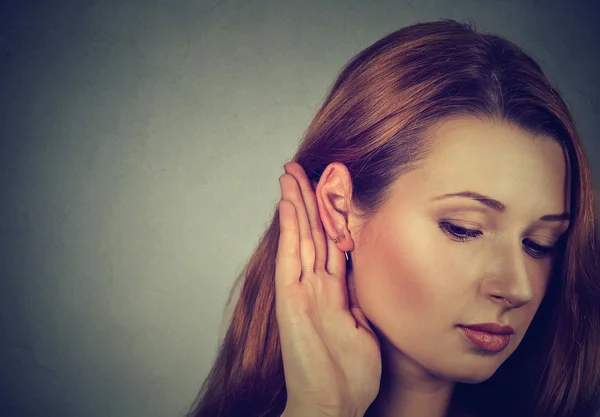 Mujer sostiene su mano cerca de la oreja y escucha con atención —  Fotos de Stock